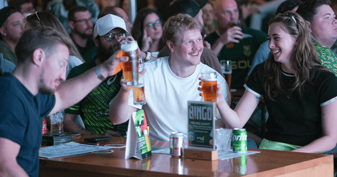 Three People Drinking At A Bar