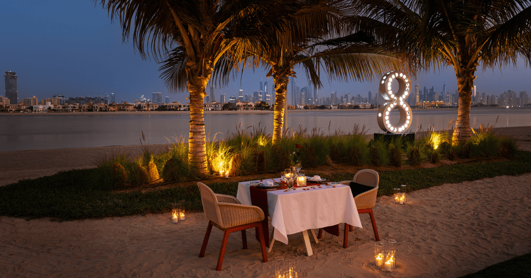 Dinner table at the beach with candles around