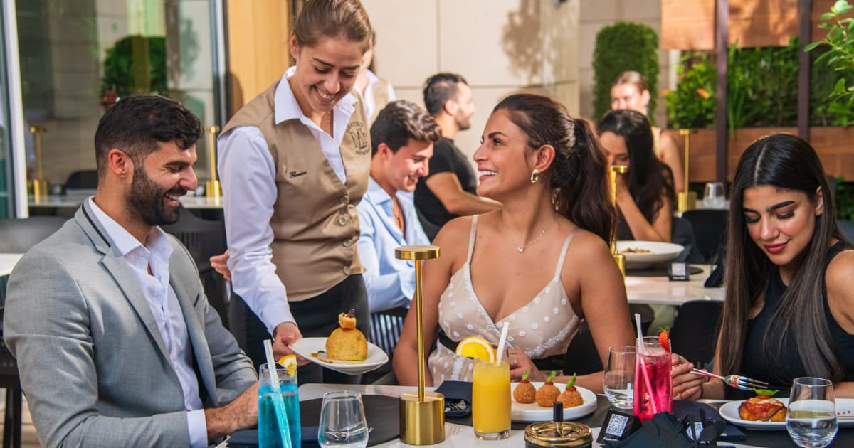 Waitress serving food to a table of people in a restaurant